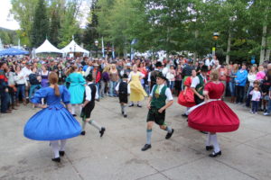 People in German costumes dancing for a crowd.